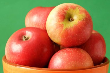 Yeşil arkaplanda kırmızı elmalar dönüyor. Yakın plan.