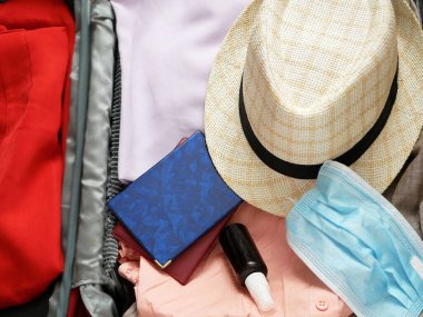 seyahat çantası, güneş şapkası, pasaportlar ve tıbbi maske ahşap arka planda, düzlük, turizm sektöründe sorunlar, covid - 19, coronavirus 