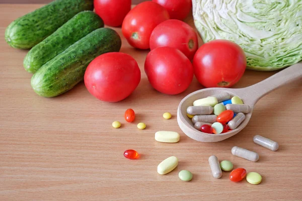 Colorful pills and capsules with fresh fruits and vegetables. Vitamins and supplement from fruits concept