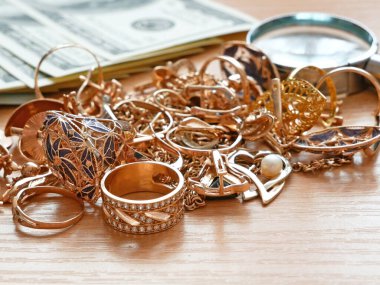 Altın, gümüş ve para mücehverleri, tefeci konsepti kuyumcu büyüteçle mücevhere bakıyor.