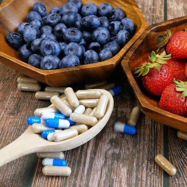 Taze meyve haplara karşı. Meyvelerdeki doğal vitamin haplardaki sentetik vitamine karşı. Doğal ve sentetik sağlık hizmetleri arasında seçim yapmak. Alternatif tıp.