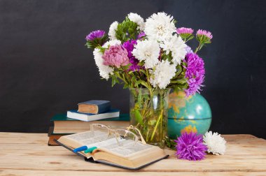 Dünya Öğretmenler Günü konsepti. Çiçekler, kalemler, küre ve kitaplar.