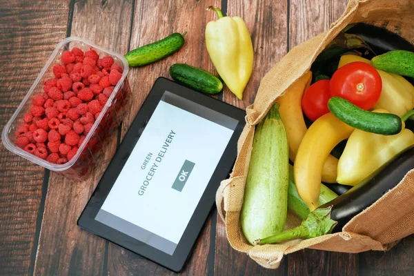Organic Vegetables and fruits in cotton bag and tablet pc, online market, green grocery delivery at home concept, buy online