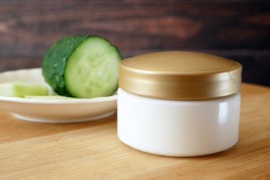 Salatalık kozmetik krem yüz ve gümüş arka planda el, cilt ve vücut bakım hijyen losyonu. Yakın çekim.