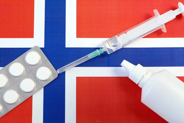 pills and syringe on Norway flag, coronavirus epidemic in Norway concept, covid - 19, coronavirus concept. virus in Norway, free vaccine for Norway people, closeup