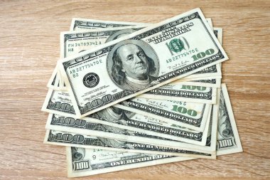 Tahta arka planda 100 ABD Doları banknot yığını, para değişimi, yakın plan