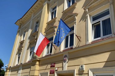 Warsaw, Poland - 6 August 2025: Polish and EU flags waving on the city council building, closeup