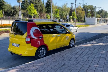 Turkey, Antalya - 6 August 2025: Yellow turkish taxi car with colourful bokeh of city street. Outdoors