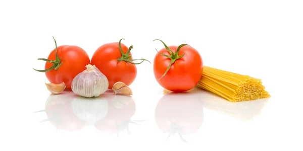 Pasta, tomaten en knoflook op een witte achtergrond — Stockfoto