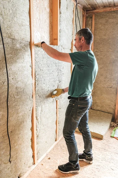 Arbetaren isolerar ett hus på landet av mineralull — Stockfoto