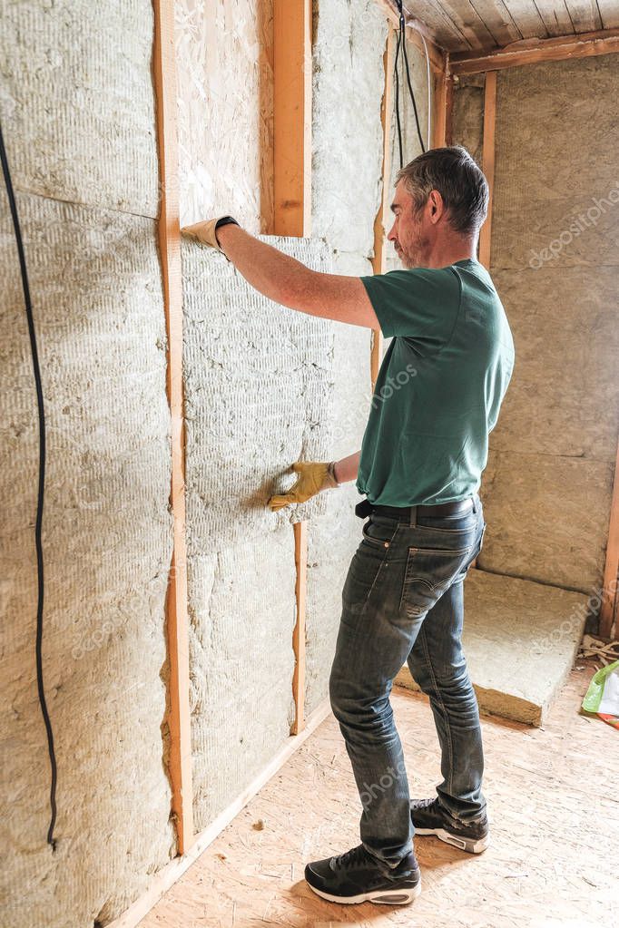 worker insulates a country house of mineral wool