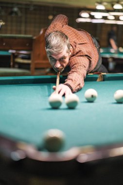 Oyuncu bilardoda topa nişan alıyor.