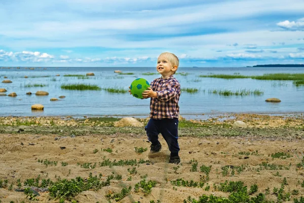 Lindo niño jugando pelota en la playa — Foto de Stock