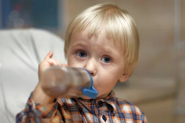 Симпатичный ребенок, пьющий из бутылки — стоковое фото