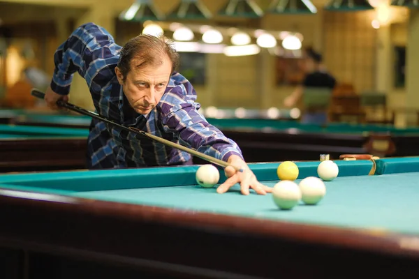 Oyuncu bilardoda topa nişan alıyor.