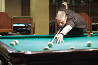 Oyuncu bilardoda topa nişan alıyor.