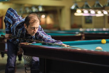 Oyuncu bilardoda topa nişan alıyor.