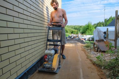 İnşaat sahasında evin etrafında kum sıkıştırma Oluşturucu