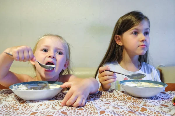 Две милые сестры позавтракают на кухне — стоковое фото