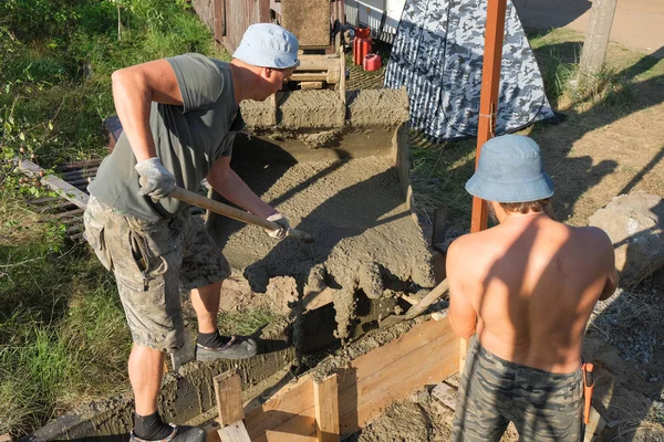 Pekerja menuangkan beton ke dalam formwork kayu — Stok Foto