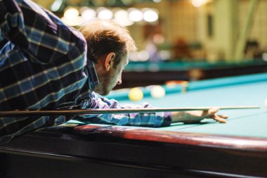 Oyuncu bilardoda topa nişan alıyor.