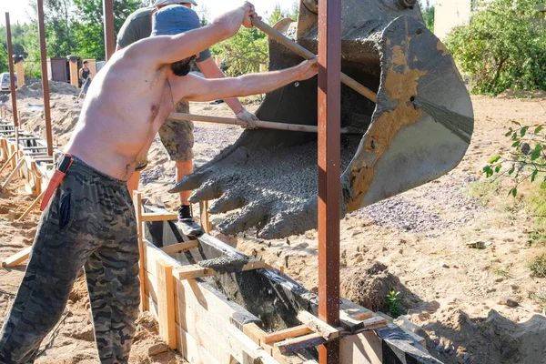 Pekerja menuangkan beton ke dalam formwork kayu — Stok Foto