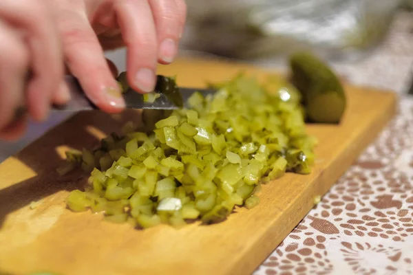 Cozinheiro corta uma salada verde em uma tábua de corte — Fotografia de Stock