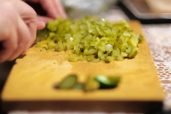 Cozinheiro corta uma salada verde em uma tábua de corte — Fotografia de Stock