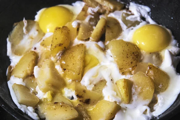 Eggs and potatoes fried in a pan — Stock Photo, Image