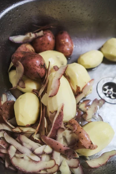 Cartofi cruzi decojiți situați în chiuveta de bucătărie — Fotografie, imagine de stoc