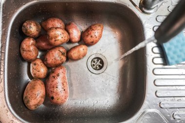 mutfak lavaboda yalan ham soyulmuş patates
