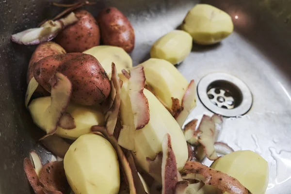 Сырой картофель лежит в кухонной раковине — стоковое фото