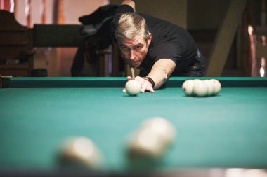 Oyuncu bilardoda topa nişan alıyor.