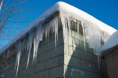 Çatıdan asılı büyük tehlikeli buz sarkıtları