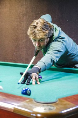 Oyuncu bilardoda topa nişan alıyor.