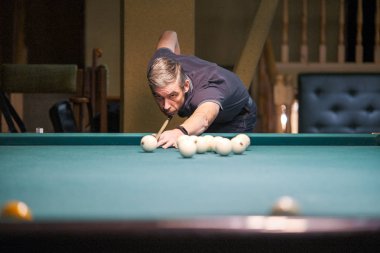 Oyuncu bilardoda topa nişan alıyor.