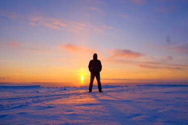 gün batımında kış manzara arka plan üzerinde bir adam silüeti
