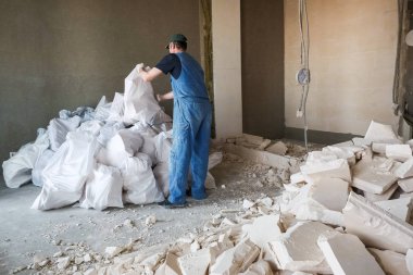 işçi yıkılan duvardan enkaz kaldırır