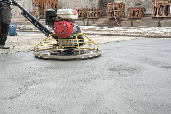 the workers grind the concrete floor at the construction site