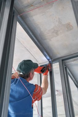 Bir işçi alçıpandan duvar yapar.