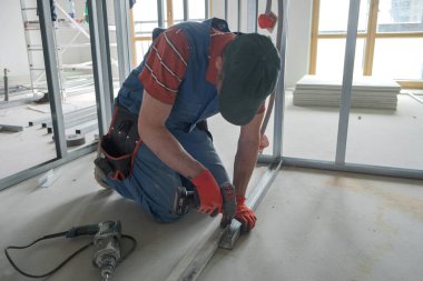 İşçi vidayı alçıpan rafına vidaladı.