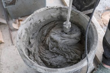 İşçi kovada çimento harcı yoğurur.