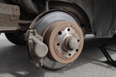 Vale üzerinde tekerleği sökülmüş eski bir araba.