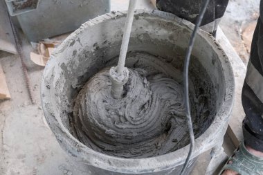 İşçi kovada çimento harcı yoğurur