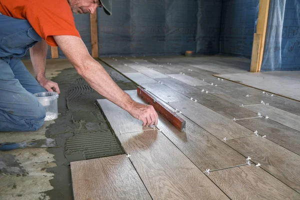 Il lavoratore mette piastrelle di ceramica sul cantiere — Foto Stock