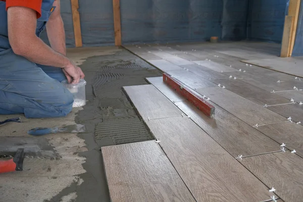 Arbetstagaren sätter keramiska plattor på byggarbetsplatsen — Stockfoto