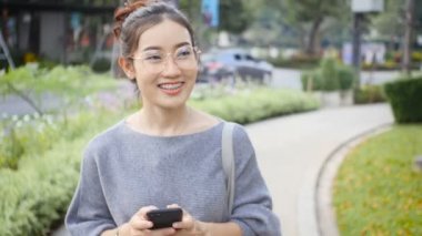 Kadın bir cep telefonu, sohbetler şehir sokaklarını arkadaşlarıyla oynuyor. Özel bir günde mutlu mu.