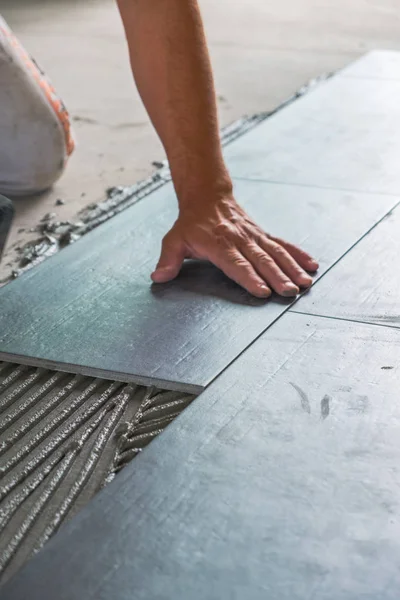 Arbeiter Legt Keramische Bodenfliesen Auf Klebefläche — Stockfoto