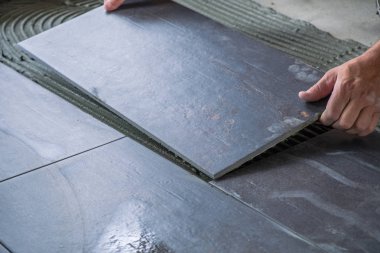 Seramik yer karoları yapışkanlı yüzeye yerleştirerek işçi