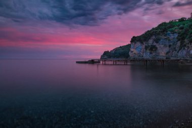 Ahşap iskele insanlarla dolu ile sahilde güzel gün batımı